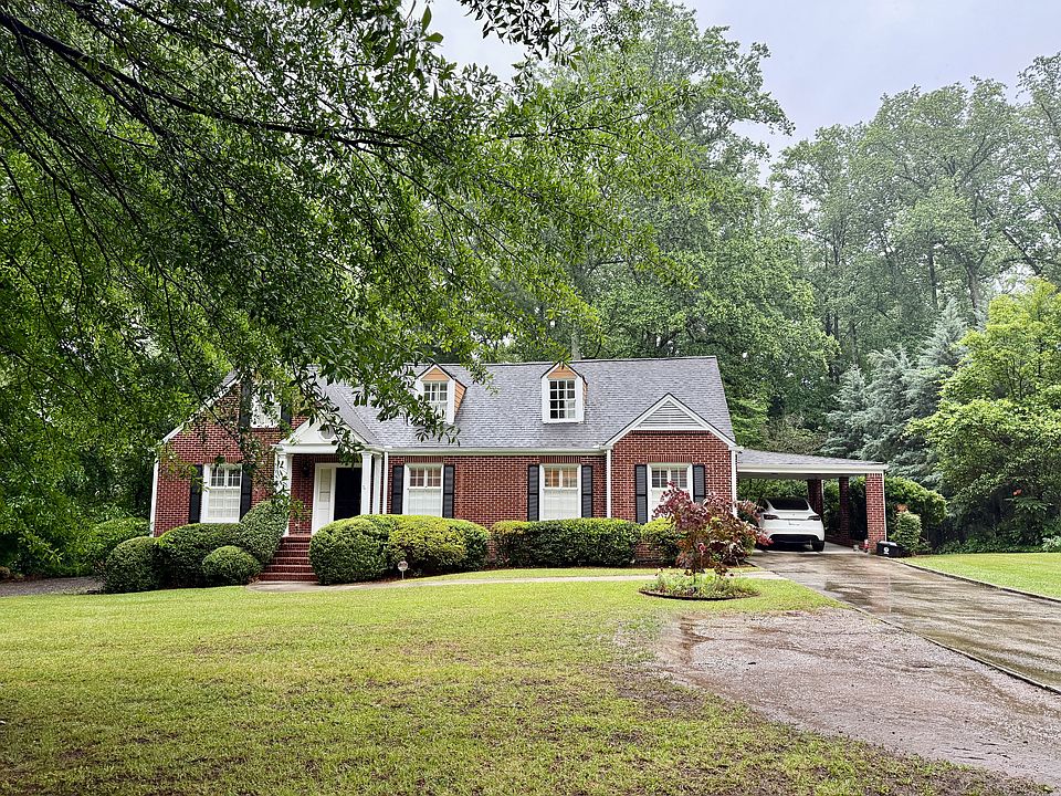 Front of the house with long driveway and carport leading to kitchen