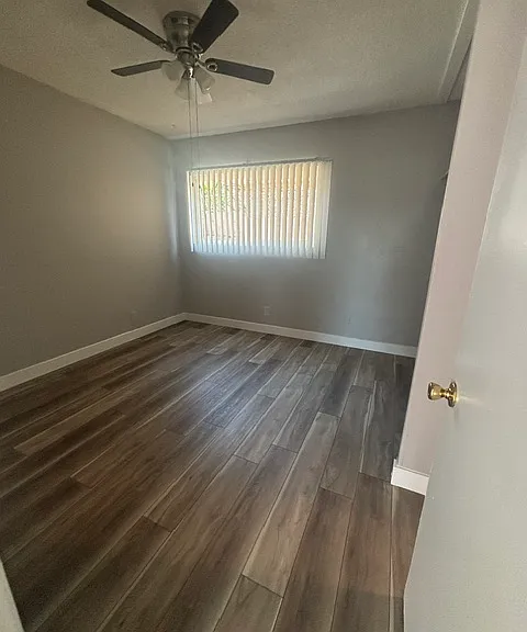 Brightly lit bedroom with new paint and vinyl plank flooring