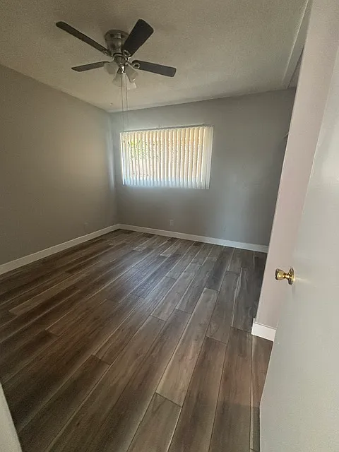 Brightly lit bedroom with new paint and vinyl plank flooring