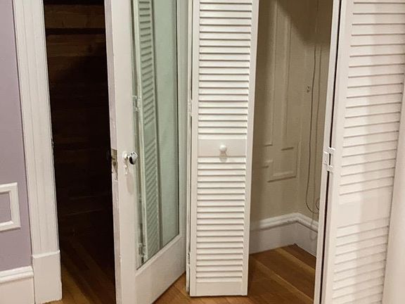 first bedroom with 2 closets and a mirror