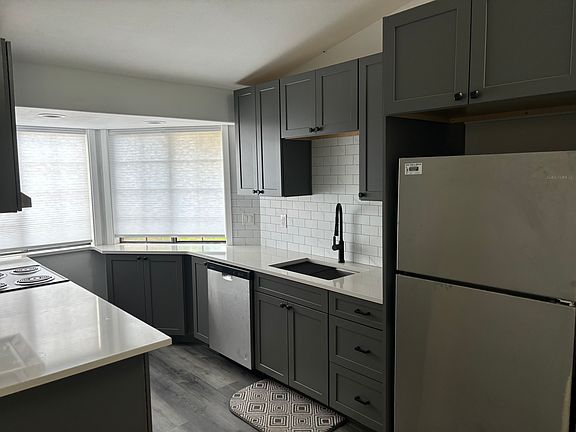 New cabinets, dishwasher, sink and faucet, refrigerator, and flooring throughout.