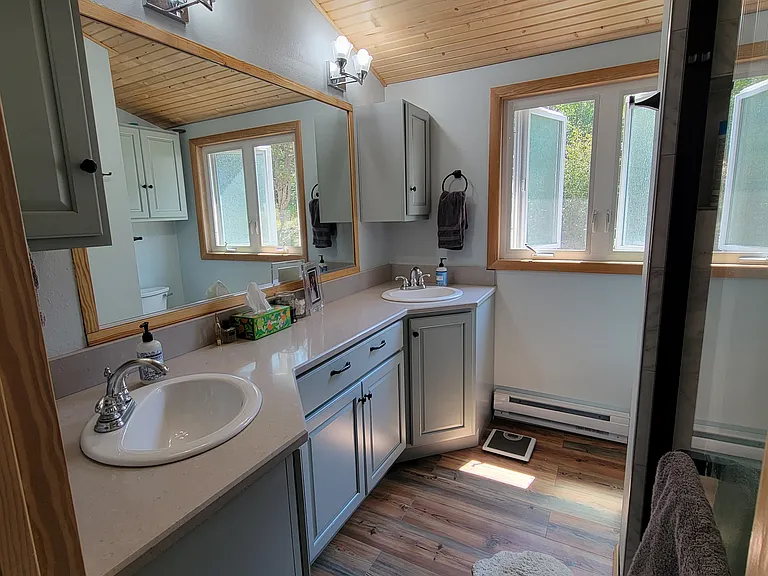 Upstairs primary ensuite 3/4 bathroom with double vanity and natural light