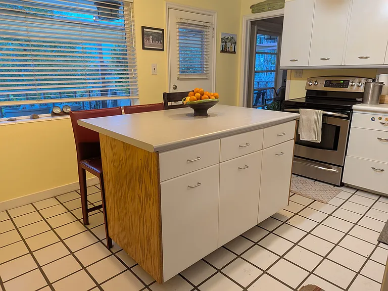 Kitchen with window and door to the back porch; entry to side room