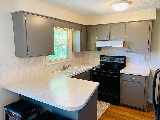 Kitchen with dishwasher, garbage disposal, oven and new stainless steel refrigerator.