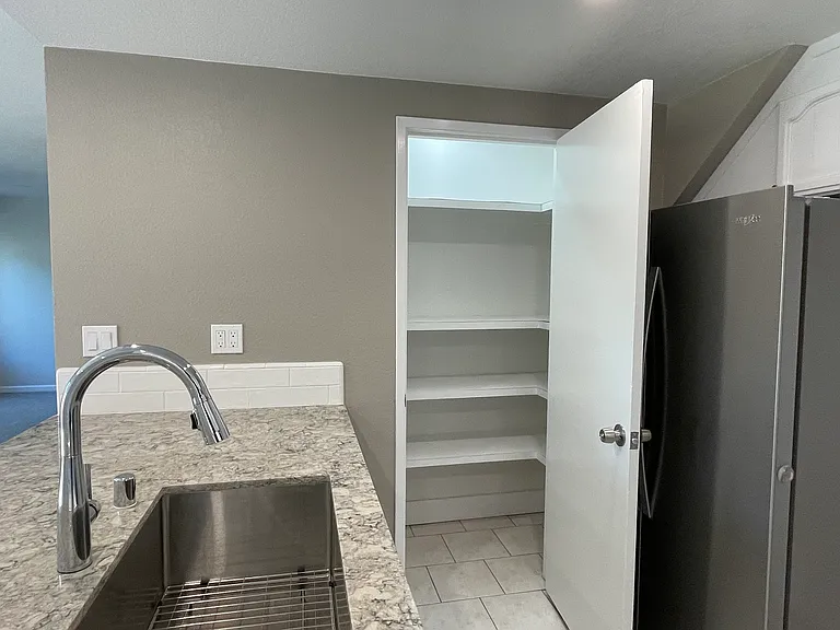 Easy access to a large pantry with new lighting and shelving inside.