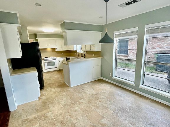 Dining area connected to kitchen and opens up to living room. Back door entry into the dining area.