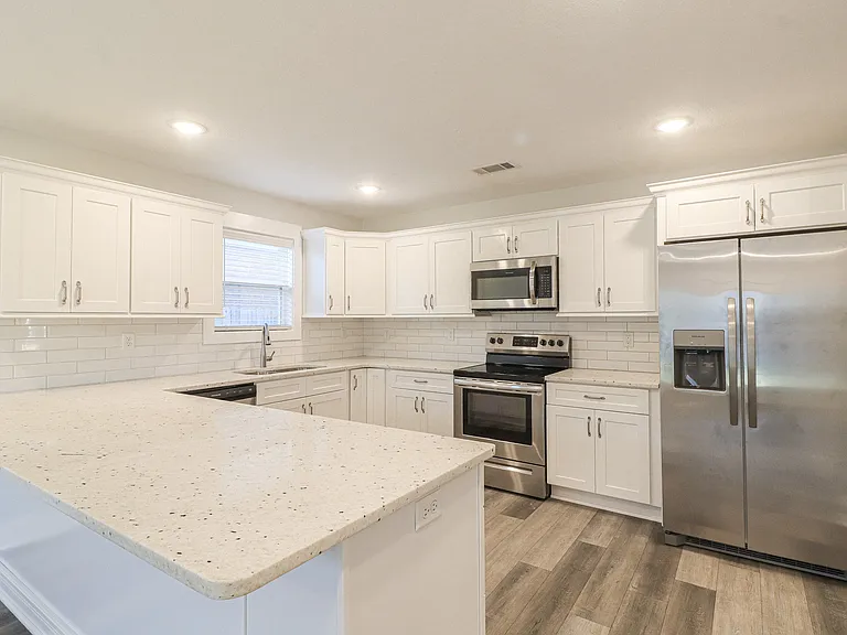 Kitchen includes refrigerator, plenty of storage and quartz countertops