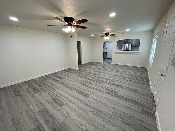 Living room looking to dining room and kitchen (wide angle shot). New floors and baseboards throughout the home.