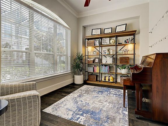 Light and bright first floor study with warm hardwood flooring and crown molding