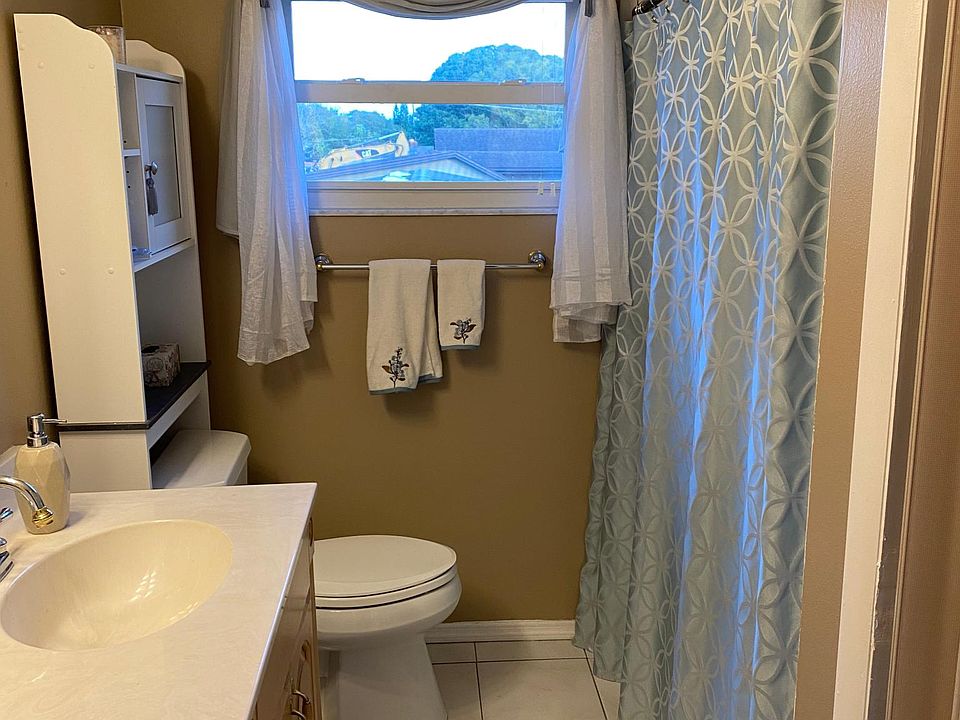 Bathroom with vanity, sink, tub/shower and stackable washer/dryer.