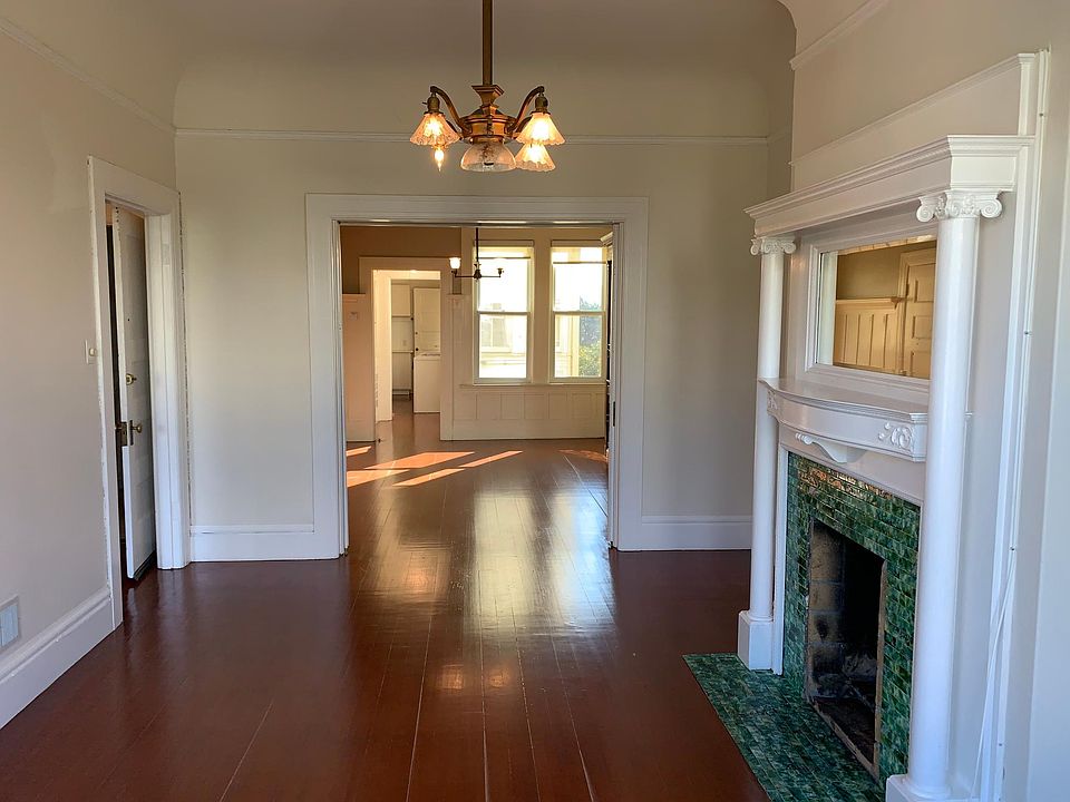 Formal living room with decorative fireplace looking into formal dining room