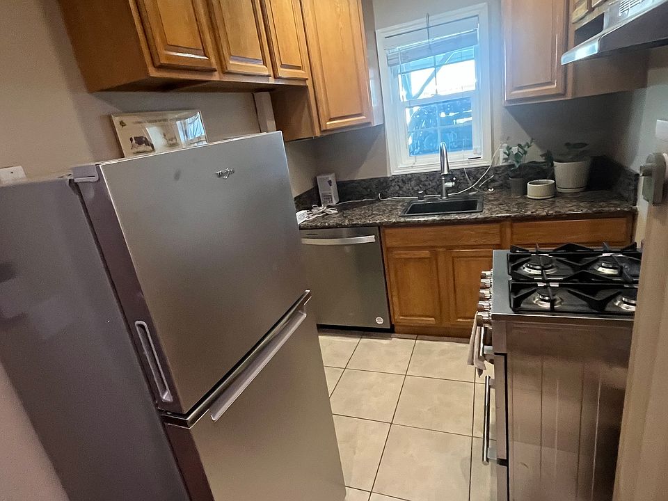 Entire kitchen with window looking out to parking area