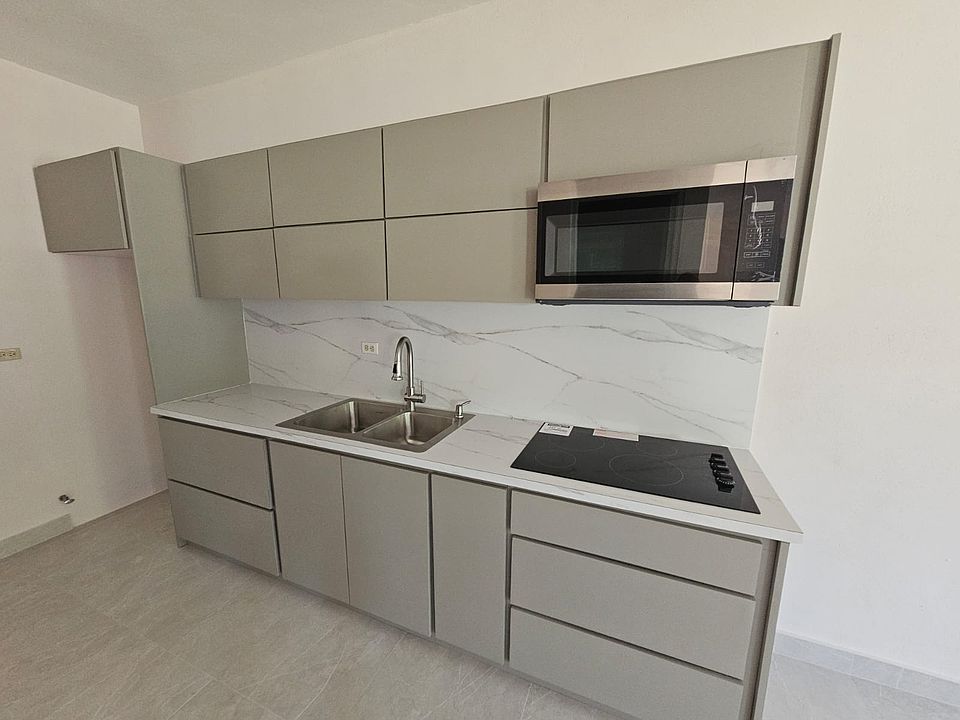 Kitchen with stove top, microwave with extractor. Modern and spacious.