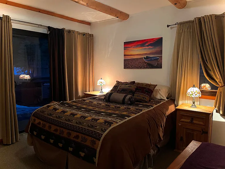 Ground level queen bedroom with sliding glass door to hot tub.