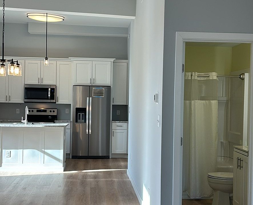 Floors are LVP and this view shows unfurnished apt and location of bathroom and kitchen.