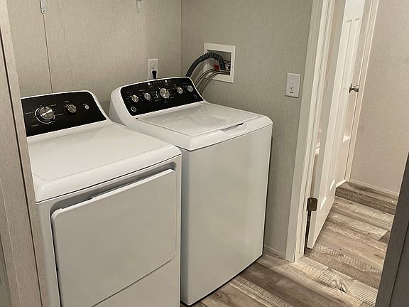 Brand new washer and dryer leading into bathroom