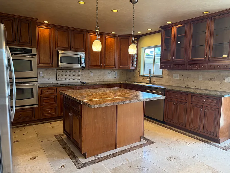 Kitchen with island counter and updated appliances.