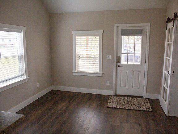 Living room with front door, entrance to second bedroom/office on the right