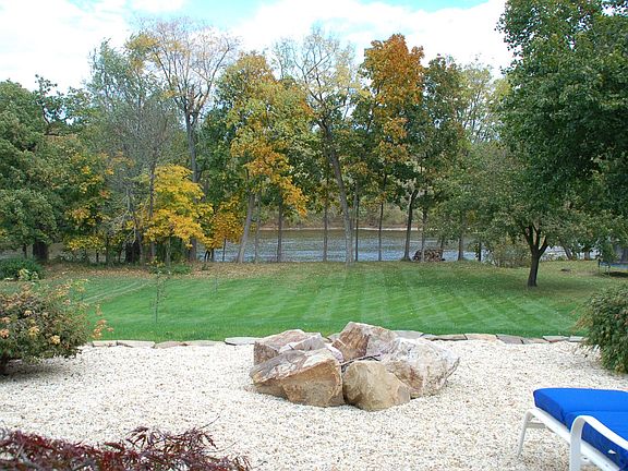 Large back yard with creek waterfront. Pebble patio with fire pit.