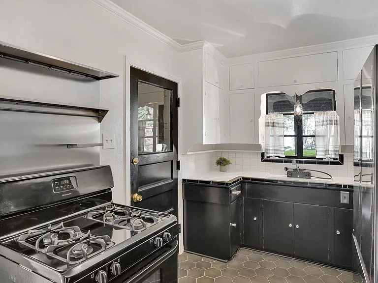 Kitchen features a gas range, ceiling exhaust, and a Samsung black stainless refrigerator.
