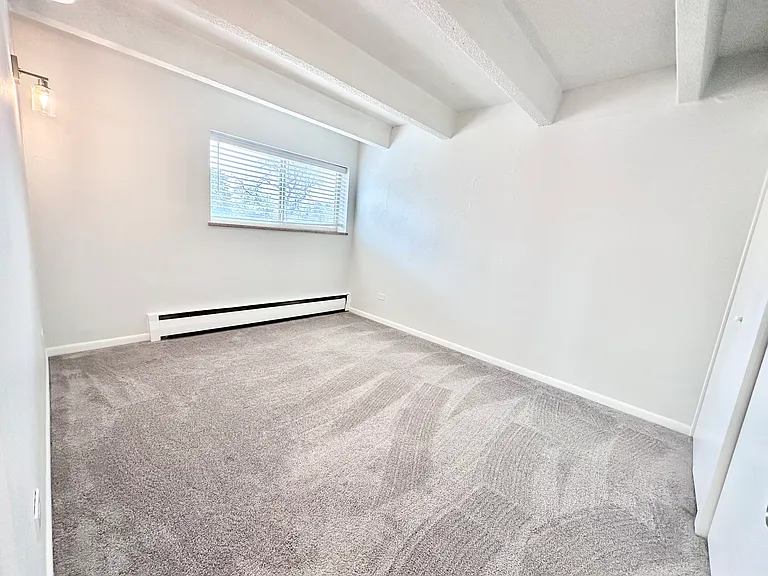 Bright and airy bedroom with soft carpet flooring, large window for natural light, and contemporary light fixture. Bright and airy bedroom with soft carpet flooring, large window for natural light, and contemporary light fixture.