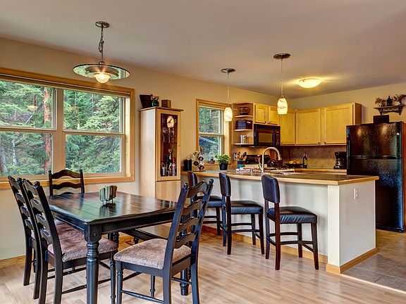 Dining area and kitchen with treed lot views