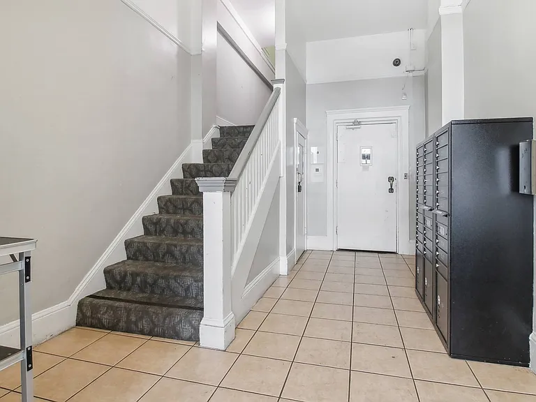 Apartment foyer with stylish decor, stairs, and mailboxes
