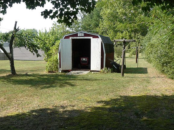 A storage shed is tucked away in the corner of the back yard