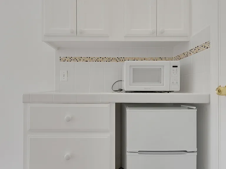 Kitchen area, small refrigerator and microwave