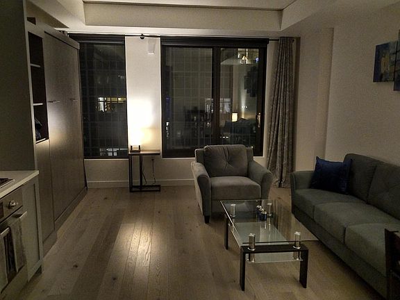Living room at night, showing fold-down bed on the left folded up
