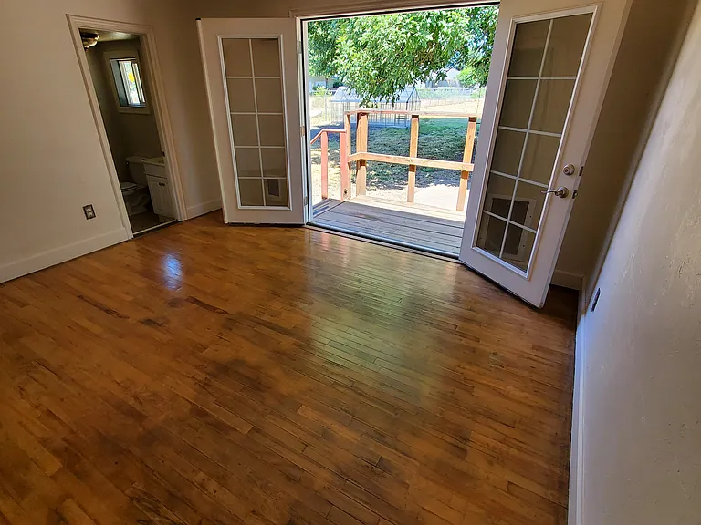 Downstairs Bedroom 2 with half-bath and French Doors to Back Porch/Deck and built-in locking dog door (to right of French Doors)