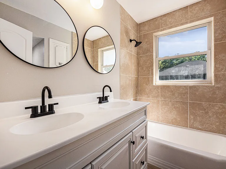 Bathroom 2 with dual vanities and shower/tub combo