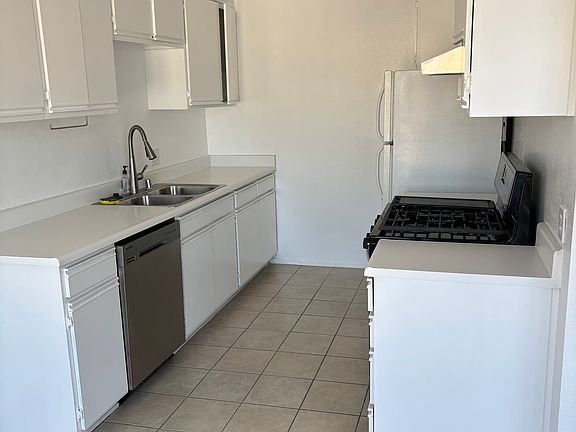 Kitchen with cabinets, refrigerator, oven/stove and dishwasher.