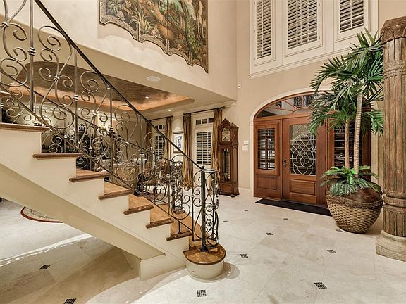 As you enter through the Double Beveled Glass Doors you will be captivated by Two Story Foyer architecture and dramatic circular Iron Staircase, attractive Travertine Floors and rich Mill Work that is prevalent throughout this home.