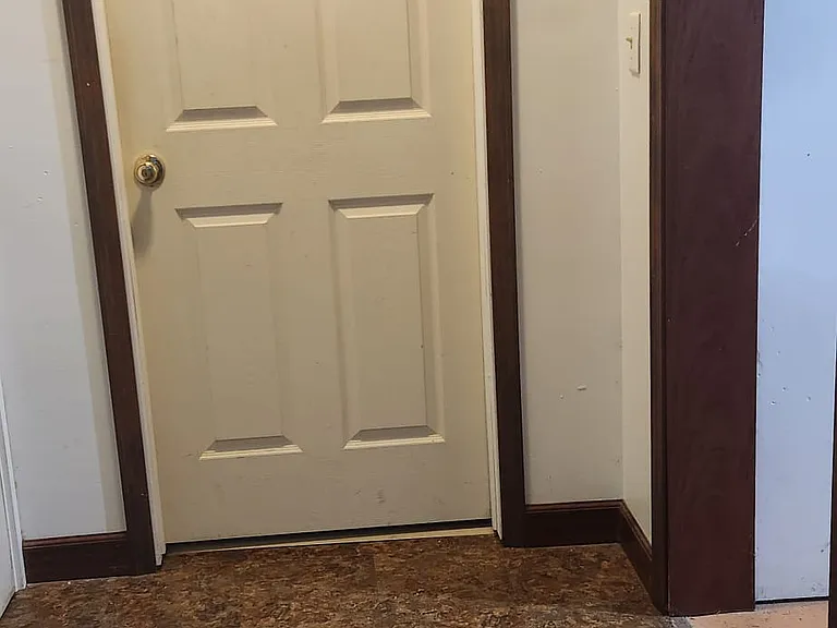 Apartment door to bedroom with opening to kitchen/laundry