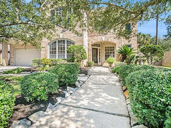 A winding, flagstone pathway adorned with lush landscaping leads up to the covered front porch!