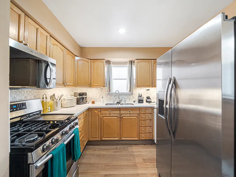 Kitchen with new appliances and double door refrigerator.