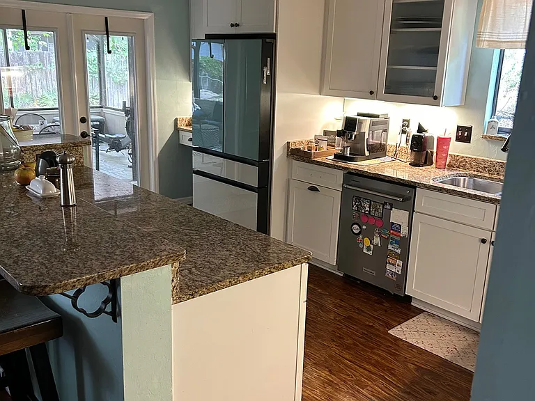 Kitchen leads to another set of french doors opening up to the large screened in porch