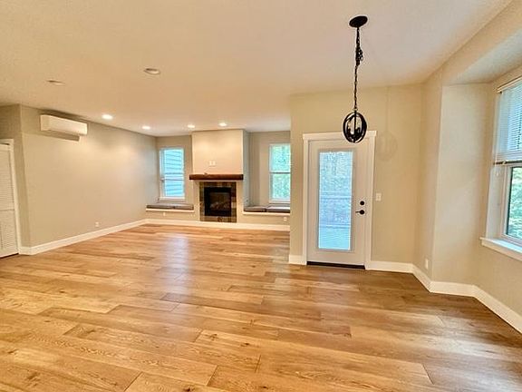 Living room features propane fireplace, efficient heat pump, designer lighting, door to deck, real wood hardwood flooring. Door opens to a deck for barbeque, etc.