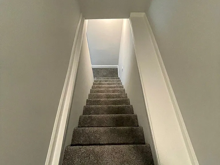 Carpeted stairs lead to (2) carpeted upstairs bedrooms