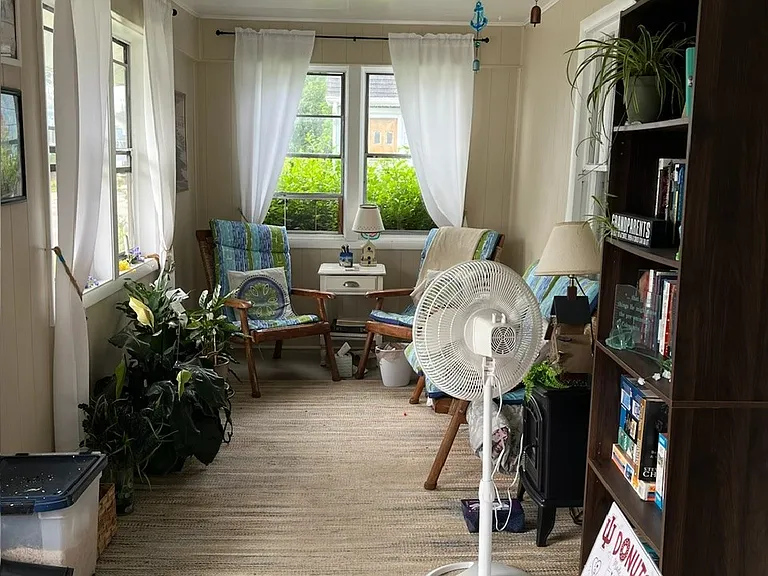 Other half of enclosed front porch with ceiling fan.