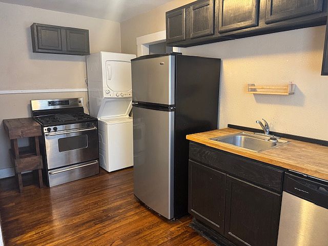 Kitchen has gas stove, fridge, dishwasher, and a stacked washer and dryer.