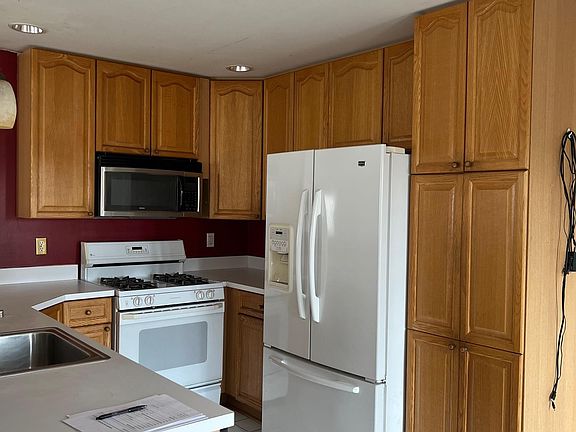 kitchen with french door refrigerator, gas range, dishwasher, and table space eating area and walk out to a huge deck.