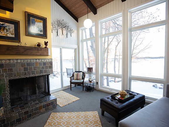 Large lake facing windows with log fireplace in living area