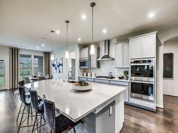 Spacious island kitchen with eat-in bartop and pendant lighting