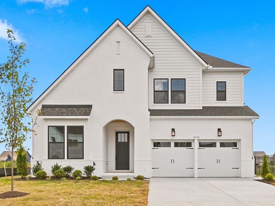 Home exterior with two car garage and dark grey accents.
