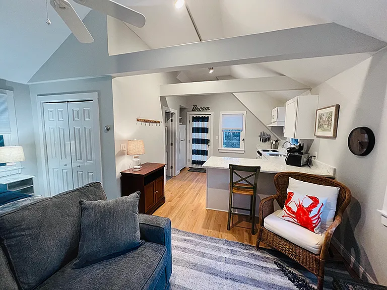 Detached Studio apartment with small kitchen, vaulted ceiling, loveseat, lounge chair, kitchen bar seating, ceiling fan, queen bed, large closet, and bathroom with shower. The Studio also has it's own laundry facilities in the garage below.