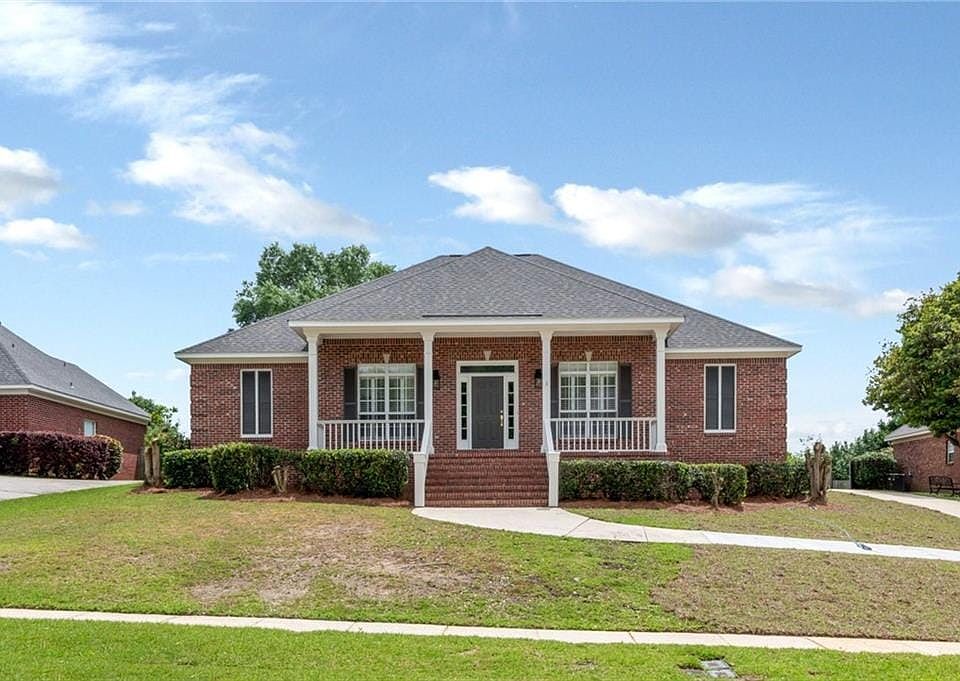 View of front of property featuring brick siding, a porch, and a front yard