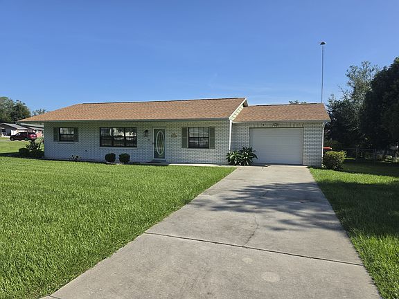 Front of the home with the long concrete driveway
