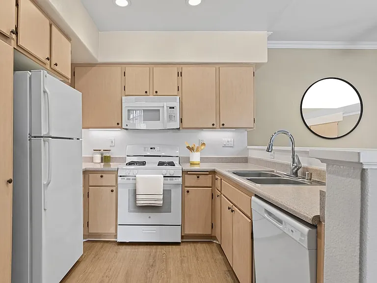 Classic Package I kitchen with white appliances, laminate countertops, oak cabinetry, and hard surface flooring